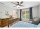 A bedroom featuring a wooden bed frame, ceiling fan, and a window offering natural light with a view to the outside at 1228 Dunwoody Walk, Atlanta, GA 30338