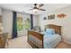 A cozy bedroom with a wooden bed frame, ceiling fan, dinosaur decorations, and a window with blue curtains at 1228 Dunwoody Walk, Atlanta, GA 30338