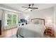 Bright bedroom with hardwood floors, large window, desk and chair, and a comfortable bed with white and blue linens at 1228 Dunwoody Walk, Atlanta, GA 30338