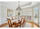 Elegant dining room with large windows, decorative chandelier, and classic furnishings at 1228 Dunwoody Walk, Atlanta, GA 30338