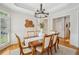 Dining area with a wooden table, six chairs, wainscoting, and shuttered windows at 1228 Dunwoody Walk, Atlanta, GA 30338