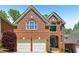 Beautiful brick home with a two-car garage, lush landscaping, and a welcoming entrance at 1228 Dunwoody Walk, Atlanta, GA 30338