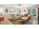 Cozy living room with plush sofas, a patterned rug, and natural light streaming through a window with forest view at 1228 Dunwoody Walk, Atlanta, GA 30338