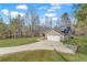 View of home's exterior showing driveway and wooded lot at 217 Lamb Rd, Moreland, GA 30259