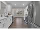 Modern kitchen with stainless steel appliances, white cabinets, and adjacent dining area at 217 Lamb Rd, Moreland, GA 30259