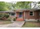 Quaint brick home featuring a tiled front entrance with a small step and manicured garden with flowering red rose bushes at 2383 N Decatur Rd, Decatur, GA 30033