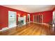 Bright living room with hardwood floors, red walls, a fireplace, and bright windows at 2383 N Decatur Rd, Decatur, GA 30033