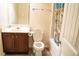 Bright bathroom featuring a single sink vanity, toilet, and shower-tub combination with a decorative shower curtain at 3830 Kittery Pt, Snellville, GA 30039