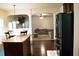 Open kitchen showcasing dark wood floors, a granite island, and stainless steel appliances at 3830 Kittery Pt, Snellville, GA 30039