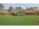Backyard with well-manicured lawn, patio dining area and view of the rear exterior of the home at 699 Rollingwood Dr, Stone Mountain, GA 30087