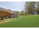 Expansive backyard featuring a well-maintained lawn, patio area with dining set, and mature trees at 699 Rollingwood Dr, Stone Mountain, GA 30087