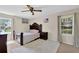 Bedroom featuring decorative wood bed frame, ceiling fan, and windows with natural light at 699 Rollingwood Dr, Stone Mountain, GA 30087