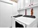 Well-lit laundry room featuring modern, front-loading washer and dryer set and storage cabinets at 699 Rollingwood Dr, Stone Mountain, GA 30087