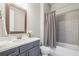 Well-lit bathroom features modern vanity with a wood trimmed mirror and shower-tub combination at 10265 Grandview Sq, Johns Creek, GA 30097