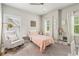 Bright bedroom featuring neutral walls, plush carpet, a cozy rocking chair, and a charming bed at 10265 Grandview Sq, Johns Creek, GA 30097