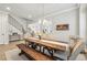 Inviting dining space with a rustic table, bench seating, a modern chandelier, and open flow to other living areas at 10265 Grandview Sq, Johns Creek, GA 30097