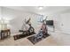 Exercise room with two elliptical machines on workout mats and a mounted TV on a console table at 10265 Grandview Sq, Johns Creek, GA 30097