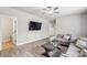 Modern living room with wood-look floors, a mounted TV, and a comfortable gray sectional sofa at 10265 Grandview Sq, Johns Creek, GA 30097