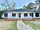 Charming single-story home with a welcoming front porch, red door, and well-maintained lawn at 134 Carrollwood Dr, Fayetteville, GA 30215