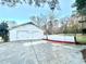 Detached two-car garage with white doors and a concrete driveway, offering ample parking space at 134 Carrollwood Dr, Fayetteville, GA 30215