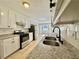 Updated kitchen features white cabinets, granite countertops, stainless steel appliances, and tile flooring at 134 Carrollwood Dr, Fayetteville, GA 30215