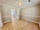 Cozy living room with wood floors, neutral walls, crown molding, and a view of the kitchen at 134 Carrollwood Dr, Fayetteville, GA 30215