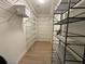 Neatly organized walk-in closet with white and black shelving units and laminate floors at 300 Johnson Ferry Rd # B105, Atlanta, GA 30328