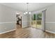 Open dining area with hardwood floors, a modern chandelier, and sliding glass doors leading to a deck for outdoor enjoyment at 4716 Alpine Sw Dr, Lilburn, GA 30047