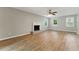 Bright living room featuring hardwood floors, a decorative fireplace, a ceiling fan and natural light streaming through multiple windows at 4716 Alpine Sw Dr, Lilburn, GA 30047