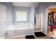 Main bathroom showcasing a large garden tub next to a window and a separate shower with a glass door at 794 Lucas Dr, Hampton, GA 30228