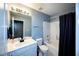 Bathroom features a shower over the tub, white vanity, modern fixtures, and a blue paint scheme at 794 Lucas Dr, Hampton, GA 30228