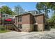 View of the back exterior, featuring brick and stone facade, stairs to deck, and driveway at 937 E Rock Springs Ne Rd, Atlanta, GA 30306