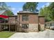 Back exterior view of home featuring a brick and stone facade with stairs to a deck and patio at 937 E Rock Springs Ne Rd, Atlanta, GA 30306