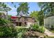 View of the brick home from the lush backyard with elevated deck and red umbrella at 937 E Rock Springs Ne Rd, Atlanta, GA 30306