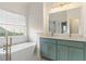 Bathroom with a double vanity and luxury soaking tub next to a shower with brass hardware at 103 St Albans Way, Peachtree City, GA 30269