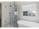 Modern bathroom featuring tiled shower, soaking tub, and window with natural light at 103 St Albans Way, Peachtree City, GA 30269