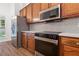 Well-lit kitchen featuring stainless steel appliances, modern countertops, and dark wooden cabinetry at 103 St Albans Way, Peachtree City, GA 30269