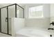 Modern bathroom features a tiled shower, a soaking tub, and a window for natural light at 1518 Gatekeeper Ter, Marietta, GA 30066