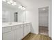 Modern bathroom with double sink vanity, large mirror, and walk-in closet access at 2109 Boxwood Se Cir, Conyers, GA 30094