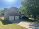Two-story home featuring a two-car garage and mature landscaping in a suburban neighborhood at 3334 Rockmill Dr, Ellenwood, GA 30294