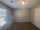 Neutral bedroom with carpet, large window, and a closet door at 1365 Jubilee Ln, Mcdonough, GA 30253