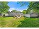 Lush backyard featuring green lawn, stone bench, walkway, and detached garage, creating a private oasis at 218 Midvale Ne Dr, Atlanta, GA 30342