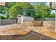 Serene backyard features flagstone patio, stone retaining wall, and a detached garage, ideal for outdoor enjoyment at 218 Midvale Ne Dr, Atlanta, GA 30342