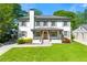 Charming two-story home with a well-manicured lawn, a covered front porch, and white painted brick at 218 Midvale Ne Dr, Atlanta, GA 30342
