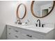 Bathroom features double sink vanity with round wood-framed mirrors and modern fixtures at 3154 N Druid Hills Rd, Decatur, GA 30033