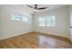 Bright bedroom featuring hardwood floors, ceiling fan, three windows, and neutral paint at 3154 N Druid Hills Rd, Decatur, GA 30033