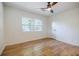 Bright bedroom featuring hardwood floors, ceiling fan, three windows, and neutral paint at 3154 N Druid Hills Rd, Decatur, GA 30033