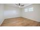 Bright bedroom featuring hardwood floors, ceiling fan, three windows, and neutral paint at 3154 N Druid Hills Rd, Decatur, GA 30033