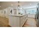 Large kitchen island with marble countertops, stainless appliances, hardwood floors, and modern pendant lighting at 3154 N Druid Hills Rd, Decatur, GA 30033