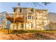 Back exterior view of the house featuring a wood deck and a spacious lawn at 4061 Preserve Trl, Snellville, GA 30039